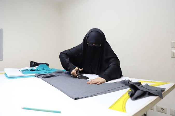 Ibtissam Abdelrahman cuts a pattern at an AlMashgel workshop
